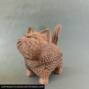 نمای نیمرخ مجسمه چوبی گربه نازکِش با دم برافراشته و رگههای چوب گردو، اثر اِچ وود