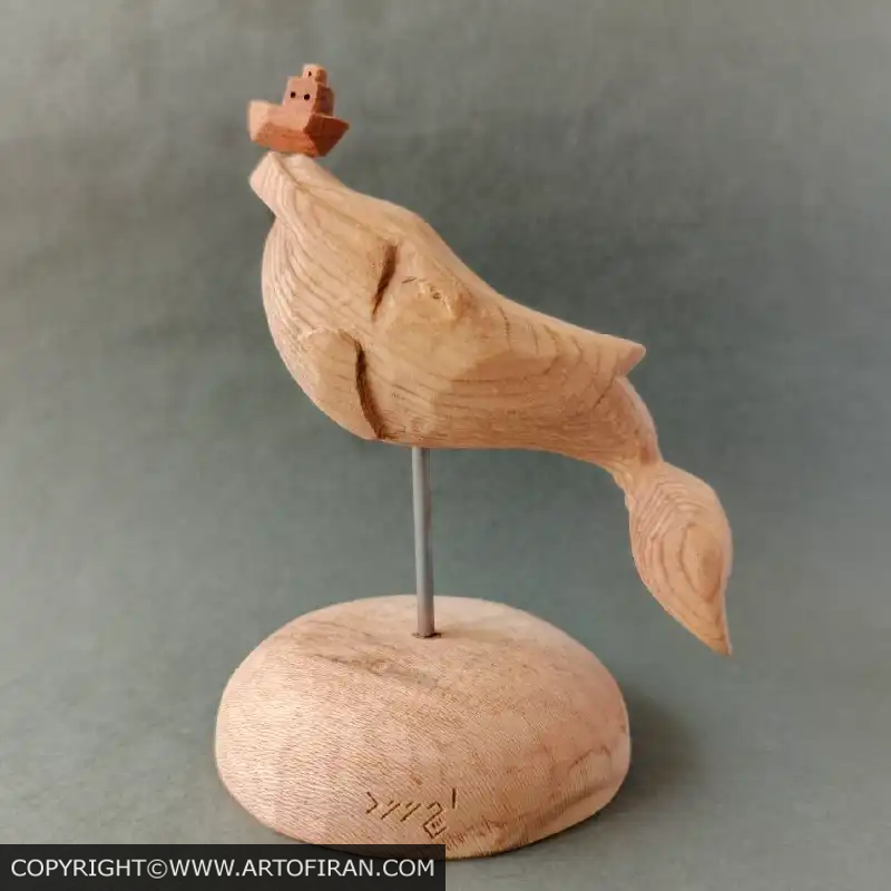 مجسمه چوبی نهنگ تنها با چوب نراد و قایق مینیاتوری روی پایه، اثر اِچ وود